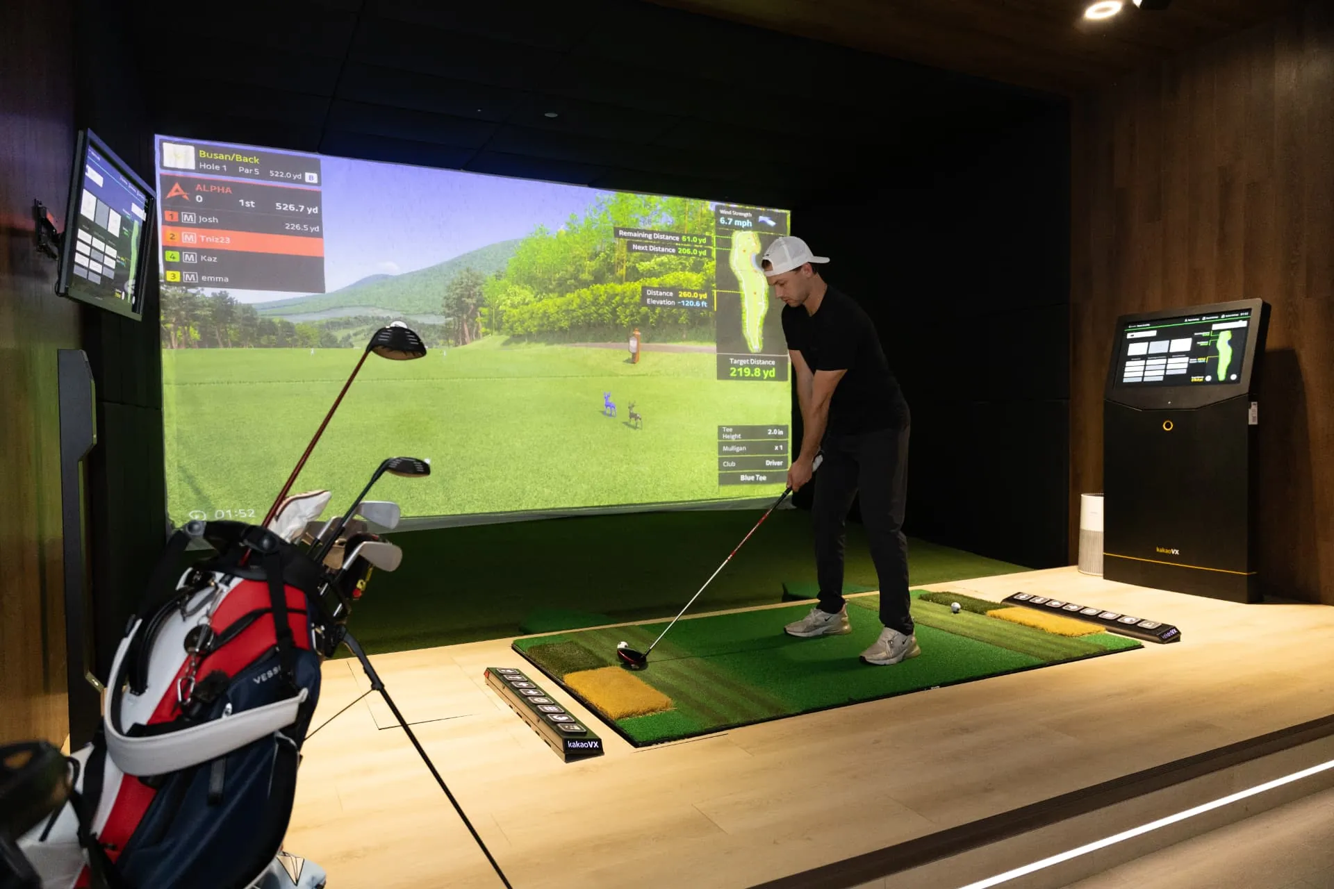 Golfer at address in a GolfVX bay on a virtual championship course